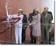 At left, Mrs. Shirley Anne Massey breaks the traditional bottle of champagne against the side of the Alaskan Legend.