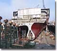 The ship's hull, shown from an aft view, begins to take shape in NASSCO's graving dock.