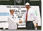 Stan Taylor (l) of the BP ship construction site team is congratulated by Richard Vortmann, President of NASSCO, after welding his initials into the keel of Hull 486, signifying the start of construction on the vessel.