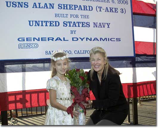 Ceremonial flower girl, Caitlin Lange, presents flowers to the Ship's Sponsor, Laura Shepard Churchley