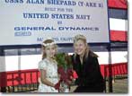 Ceremonial flower girl, Caitlin Lange, presents flowers to the Ship's Sponsor, Laura Shepard Churchley