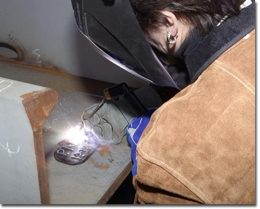 General Dynamics Senior Vice President Phebe Novakovic welds her initials into the T-AKE 5 keel plate.