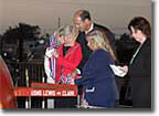 Jane Lewis Sale Henley (in red), the fourth great grandniece of Meriwether Lewis, and Lisa Clark (in blue), the fourth great granddaughter of William Clark, prepare to christen the USNS Lewis and Clark. They are being assisted by Richard Vortmann, president of General Dynamics NASSCO, and their Matrons of Honor, Jody Travers Clark Small (in black) and Ann Meriwether Henley Yauger (in white).