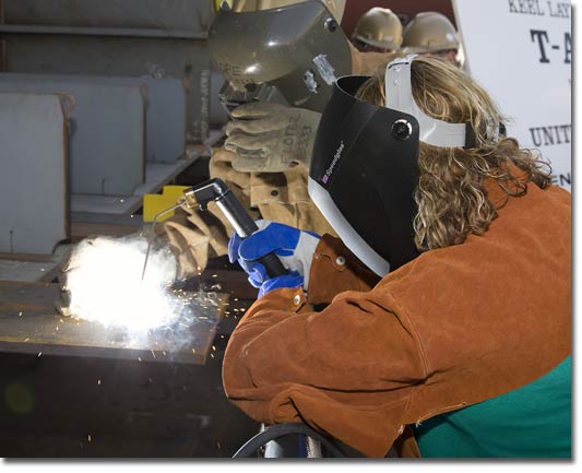 Mrs. Peggy Harris, wife of NASSCO President Fred Harris, welds her initials into the keel of T-AKE 10 on March 17, 2009.