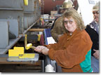 Mrs. Harris prepares to drive the fit-up wedge for the T-AKE 10 keel.