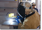 Ms. Barbara Whaley, a SUPSHIP San Diego production group manager, welds her initials into the keel plate of T-AKE 11 on August 25, 2009.
