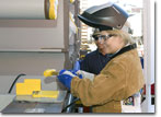 Ms. Whaley drives the fit-up wedge for T-AKE 11's keel.