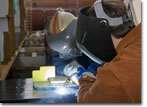 Mrs. Tess Landay, wife of the Navy's Program Executive Officer for Ships RADM Bill Landay, welds her initials into the keel of T-AKE 12 on March 26, 2010.
