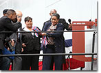 Mrs. Myrlie Evers swings to break the traditional bottle of champagne against the USNS Medgar Evers as TAKE-13 is christened.