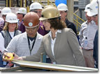 Mrs. Zigelman, wife of NASSCO's Director of Contracts and Estimating Charlie Zigelman, measures the first metal part cut for T-AKE 13.