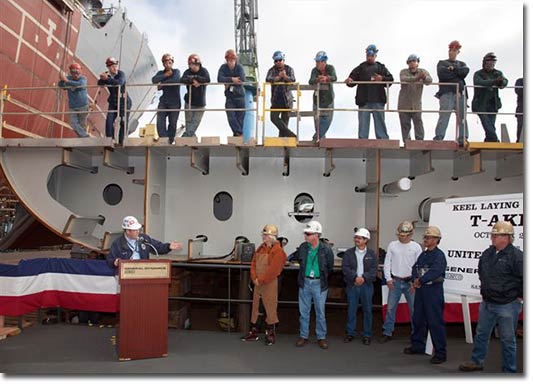 Brian Ruiz introduces Mrs. Buzby at the ceremony, with members of the construction crew observing.