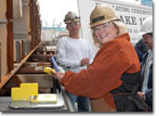 Mrs. Buzby prepares to place the plaque with her initials on the keel.