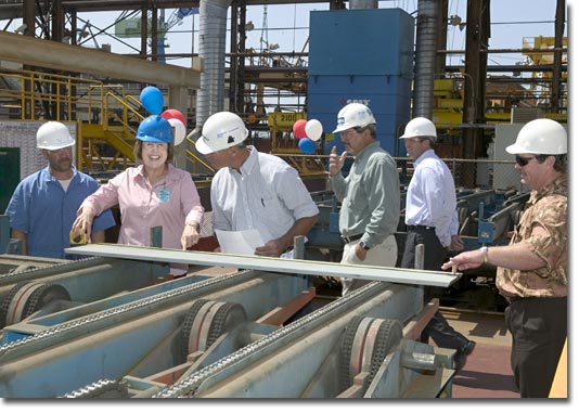 Mrs. Mary Knierim measures the first piece of steel for T-AKE 5.