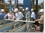 Mrs. Mary Knierim measures the first piece of steel for T-AKE 5.