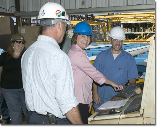 Mrs. Mary Knierim starts the robotic steel cutter to begin T-AKE 5's construction.