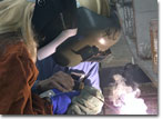 The Navy's Program Manager for Auxiliary Ships, Ms. Bilyana Anderson, welds on the keel of T-AKE 7.