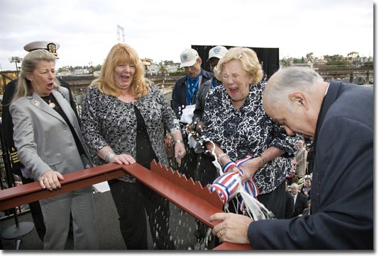 Ship's Sponsor Mrs. Wally Schirra breaks the christening champagne bottle at the launch of T-AKE 8.