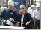 Mrs. Kukuchek checks the first metal part cut for T-AKE 9.